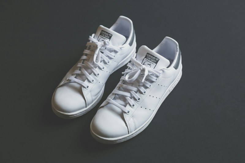 Pair of white low-top sneakers in a mock ad promising 20% off